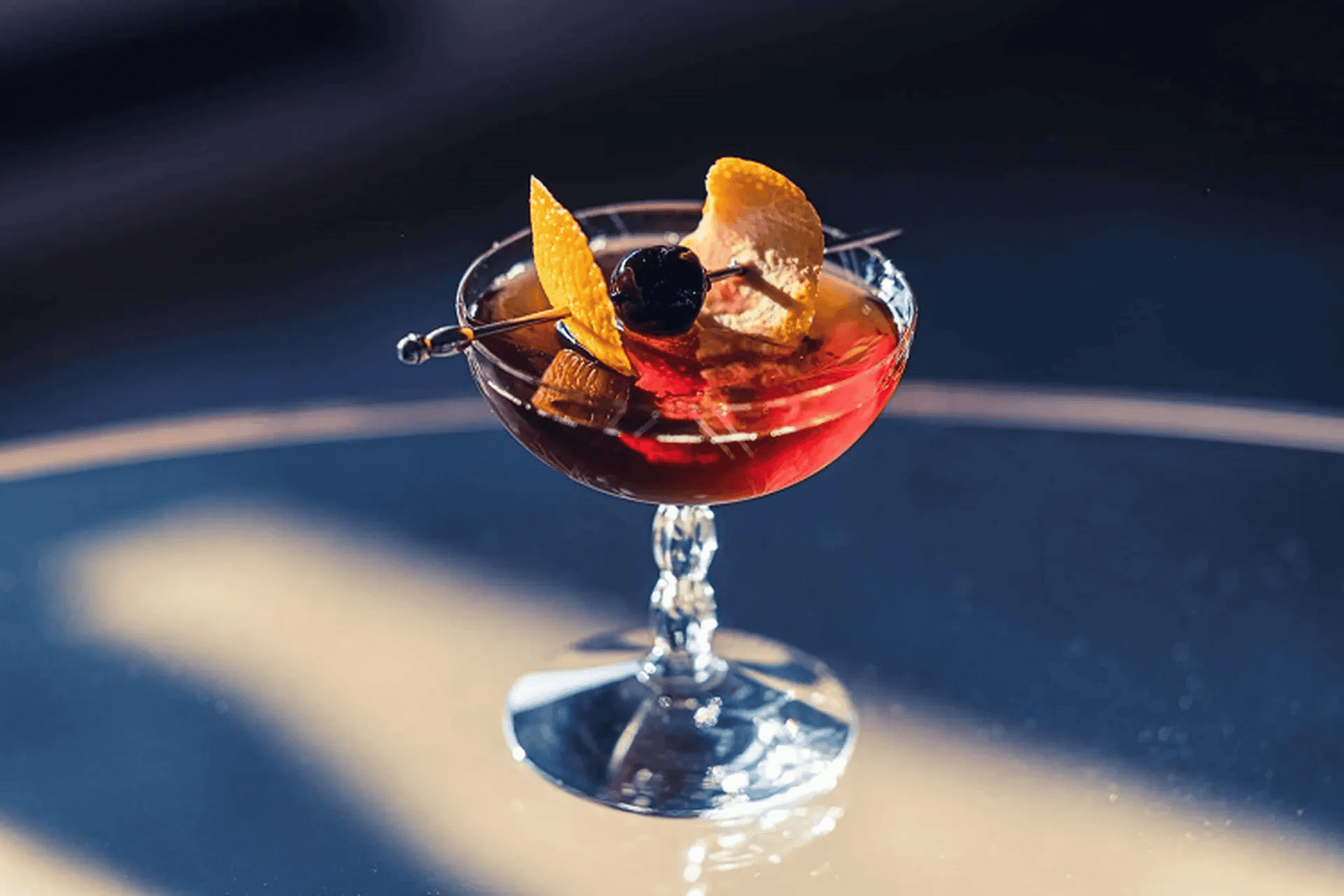 Manhattan cocktail cổ điển trong coupe glass với Luxardo cherry garnish — công thức chuẩn IBA 3 nguyên liệu