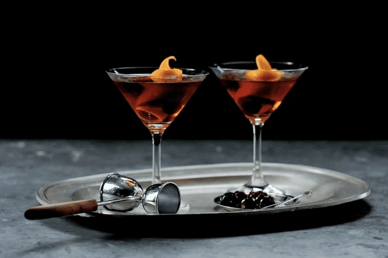 Speakeasy thập niên 1920s Prohibition era — nơi Manhattan cocktail sống sót và được uống lén lút suốt 13 năm cấm rượu