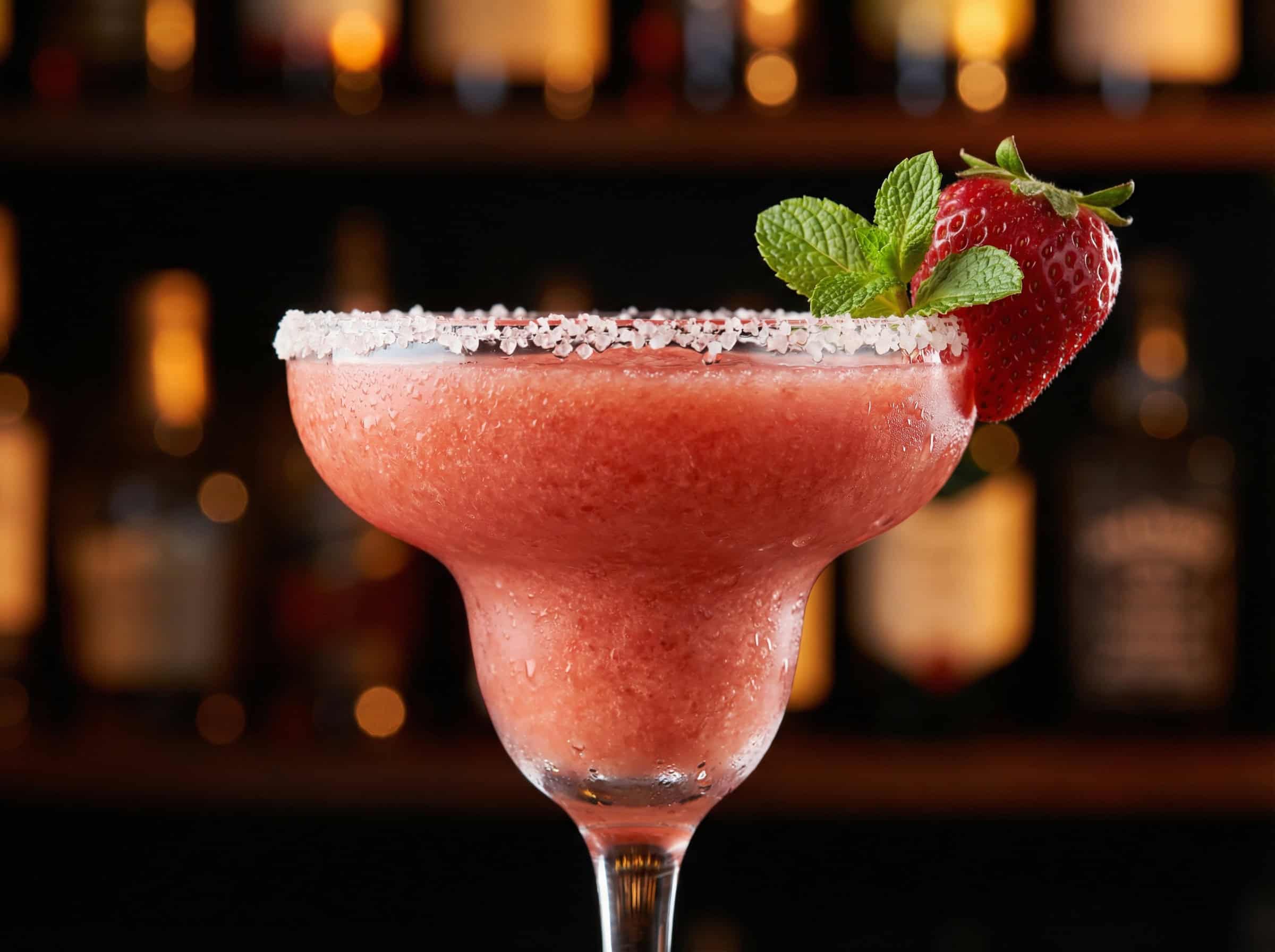 Strawberry Margarita trong ly coupe với vành muối hạt và dâu tây tươi garnish — màu đỏ đặc trưng
